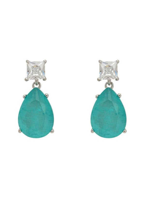 Pair of earrings with blue teardrop stones and clear gemstones on a white background