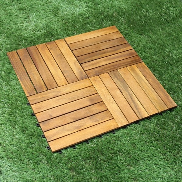 Wooden decking tiles arranged in a square pattern, showcasing rich brown tones and smooth, polished surfaces on a grassy background