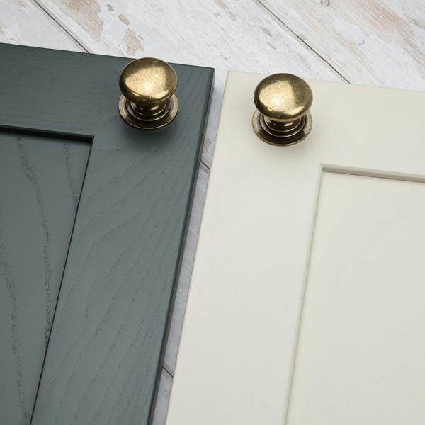 An antique brass round curved classic traditional knob