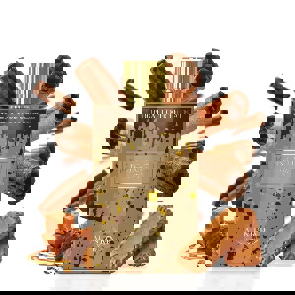 Bottle of Dubai Chocolate with cinnamon sticks and cookies on a white background