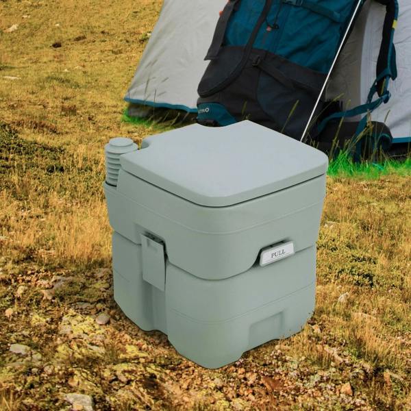 Grey portable camping toilet with lid closed on outdoor campsite ground
