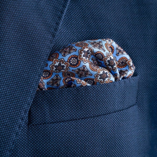 'Millefiori' silk pocket square in mid blue with orange by Otway & Orford folded in top pocket