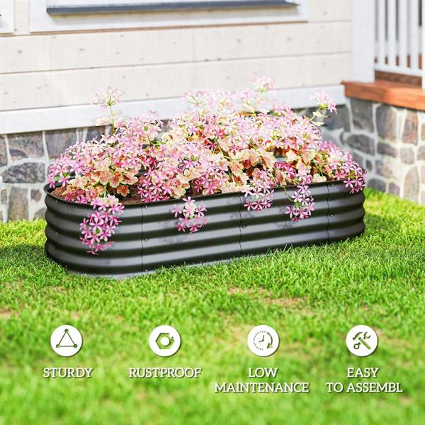 Dark grey metal raised garden bed with dense pink flowering plants on grass