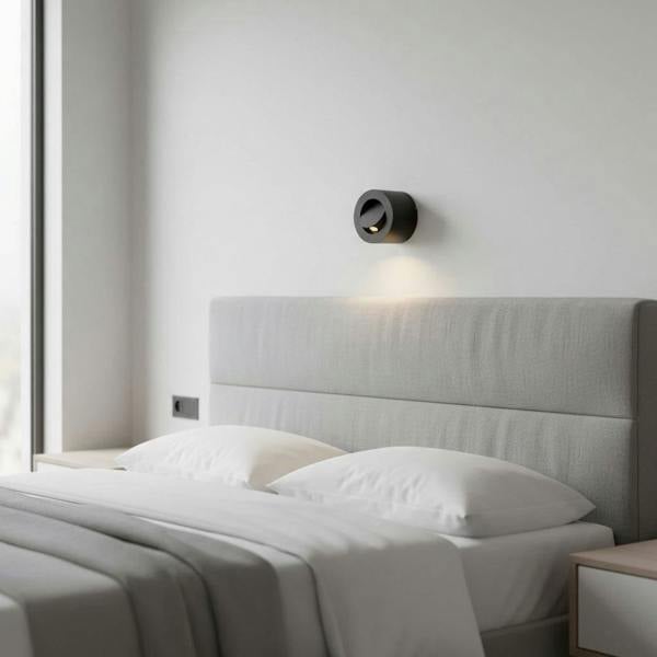 black bedside light for reading mounted on the wall over a bed in a modern minimal bedroom