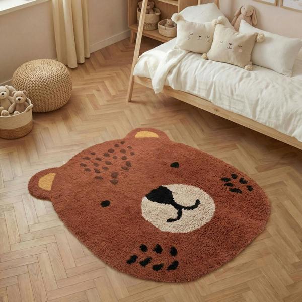 Bear-shaped rug on a wooden floor in a child's room with a bed and toys.