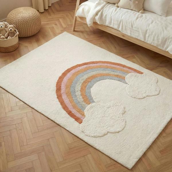 Beige rug with rainbow and cloud design on a wooden floor
