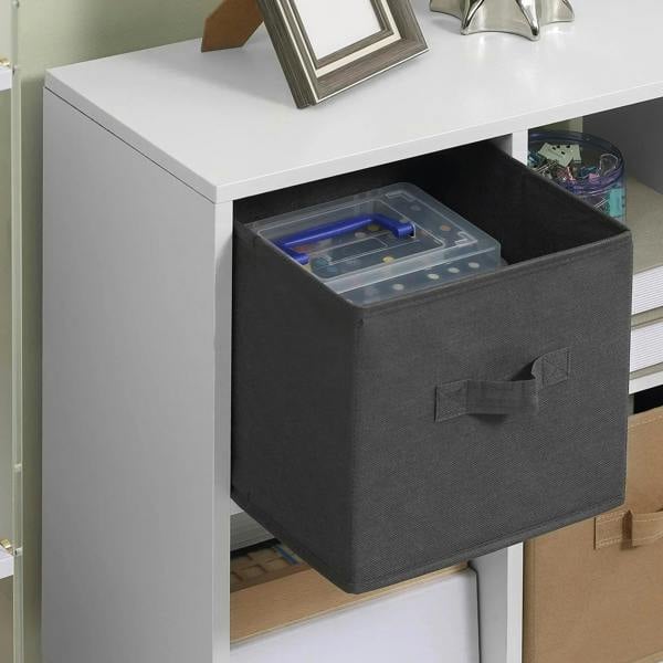 Close-up of a black fabric drawer sliding into a white 4-cube cabinet compartment