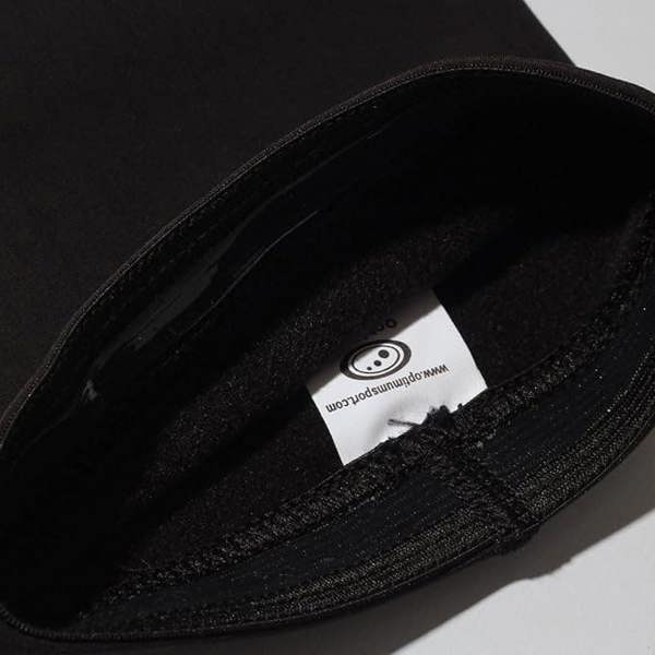 Close-up of black Optimum Hawkley arm warmer with white sewn-in branded care label - Optimum