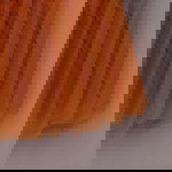 Close-up of an orange tulle skirt on a neutral background