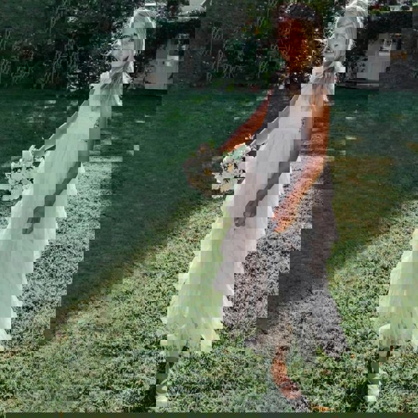 Girl in a garden wearing ivory flower girl dress