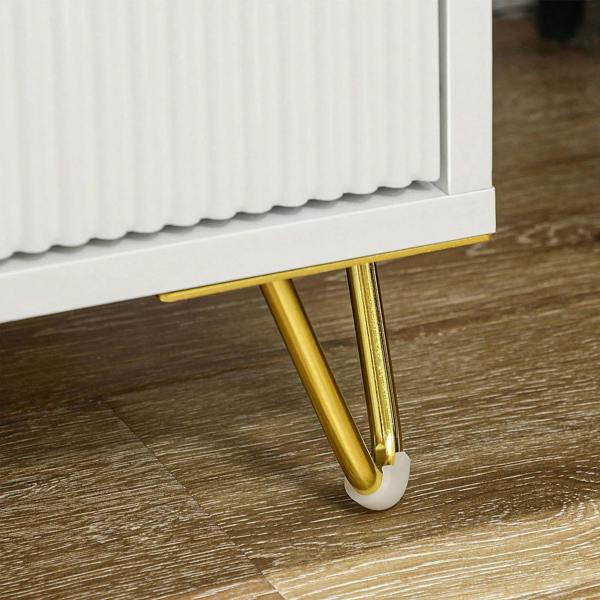 Close-up of white chest base with gold legs and foot glides