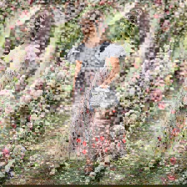 Young girl in a floral dress standing amidst a floral archway