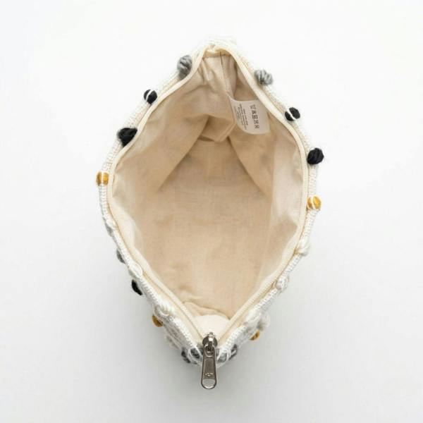 Nomad Sari toiletry bag interior view, beige lining with drawstring and metal zipper.