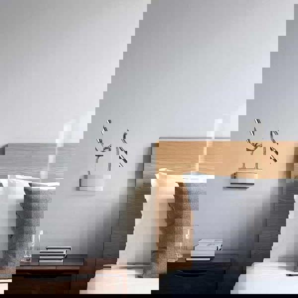 polished chrome over bed reading light mounted next to a bed in a modern bedroom