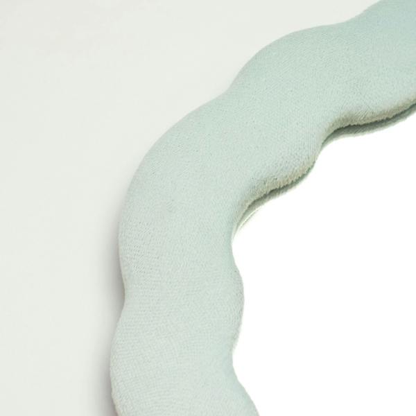 Close-up of cloud blue squiggly mirror fabric texture with rounded cutout