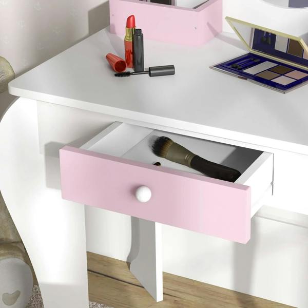 Kids dressing table with open drawer and beauty tools on a white tabletop with pink trim.