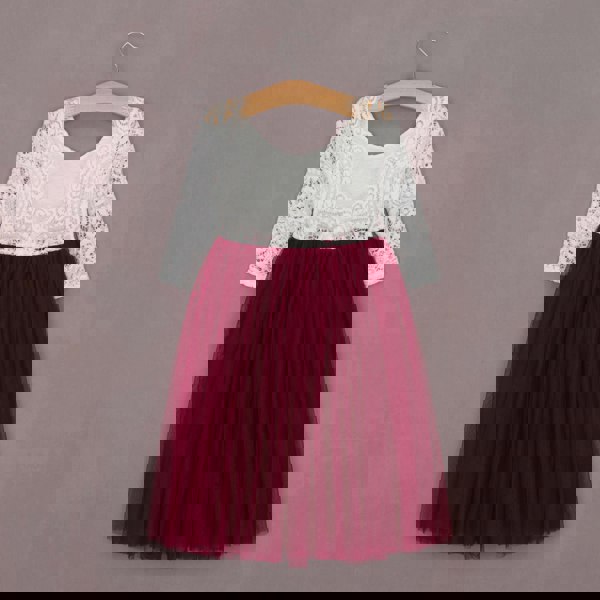 White lace top and red tulle skirt dress on a hanger against a gray background