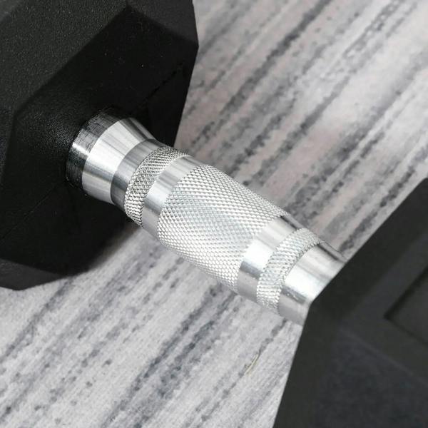 Knurled steel grip detail on a black rubber hex dumbbell.