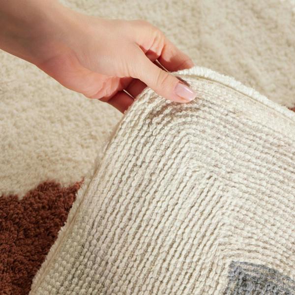 Close-up of a hand touching a textured fabric surface