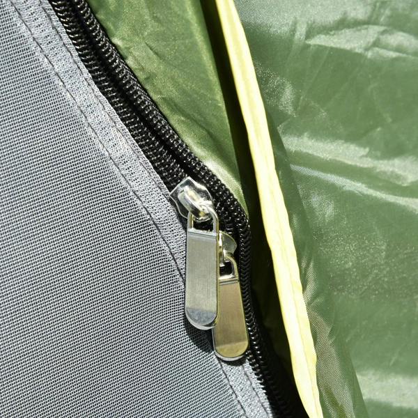 Tent zipper with metal slider on green fabric, near mesh edge close-up