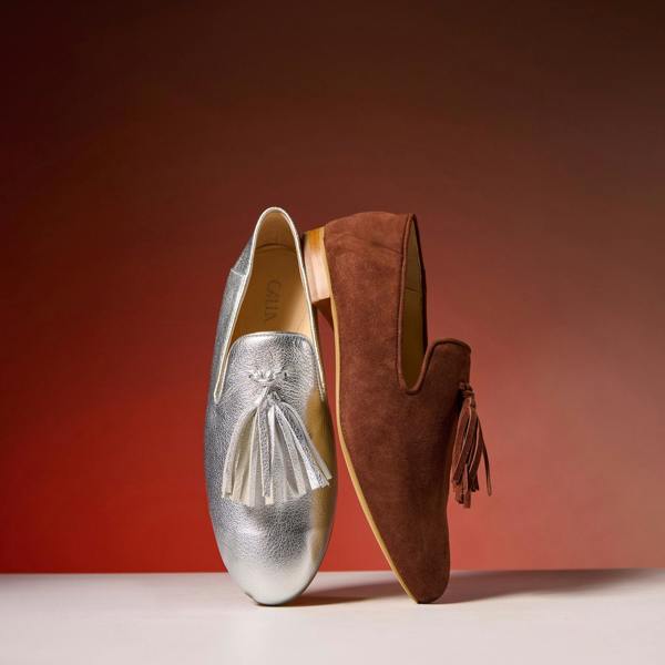 silver and brown loafers on a red background