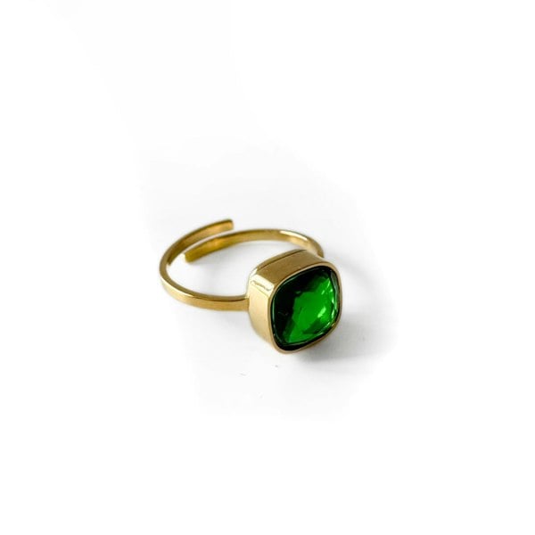 Gold ring with a green gemstone on a white background