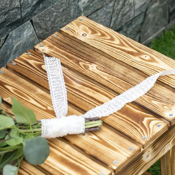 Close-up of slatted wooden bench seat with knots and metal screws