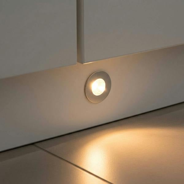 chrome led plinth light shown mounted in a white low level kitchen plinth 