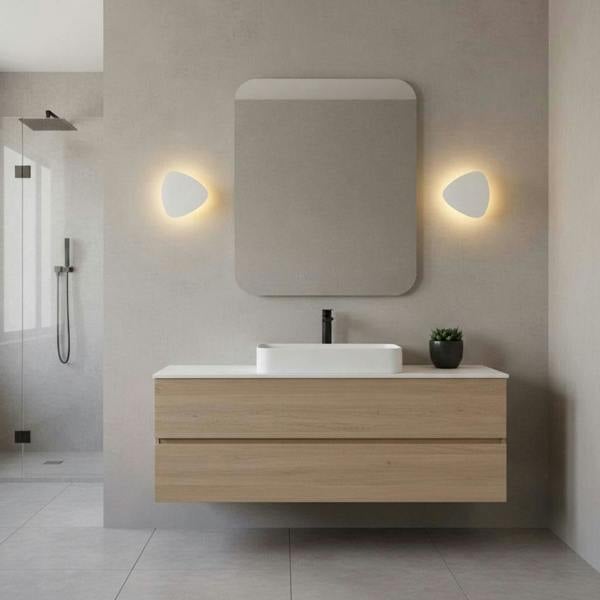 white wall mounted vanity light mounted either side of the mirror in a modern bathroom 
