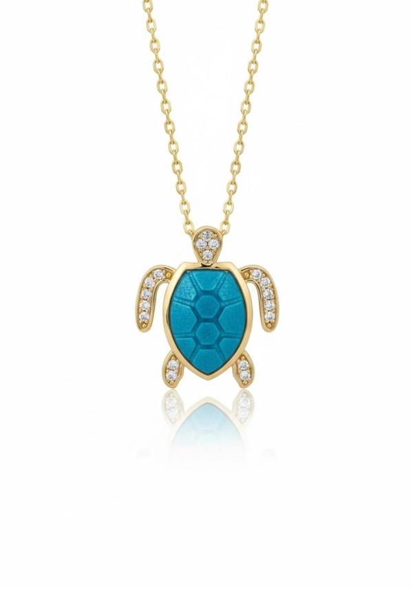 Gold turtle pendant with turquoise center and clear stones on a gold chain against a white background