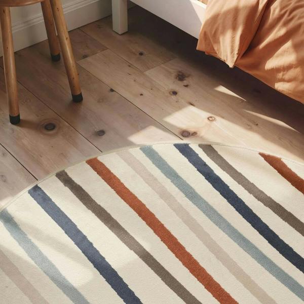 Round rug with multicolored striped pattern on a white background