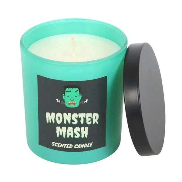 Teal jar scented candle with lit wick and black label, green monster graphic, lid off