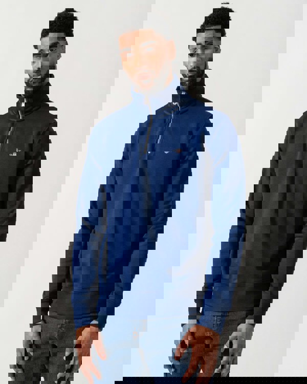 Model wearing GANT Mens Regular Fit Shield Logo Half Zip Sweatshirt in 432 Rich Navy - Main