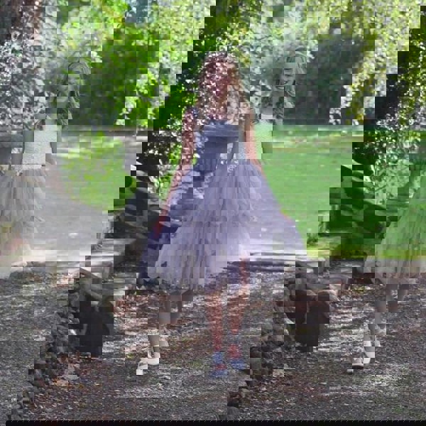 young girl stood under tree