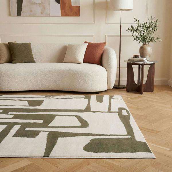 Living room with a beige sofa, patterned rug, and side table.