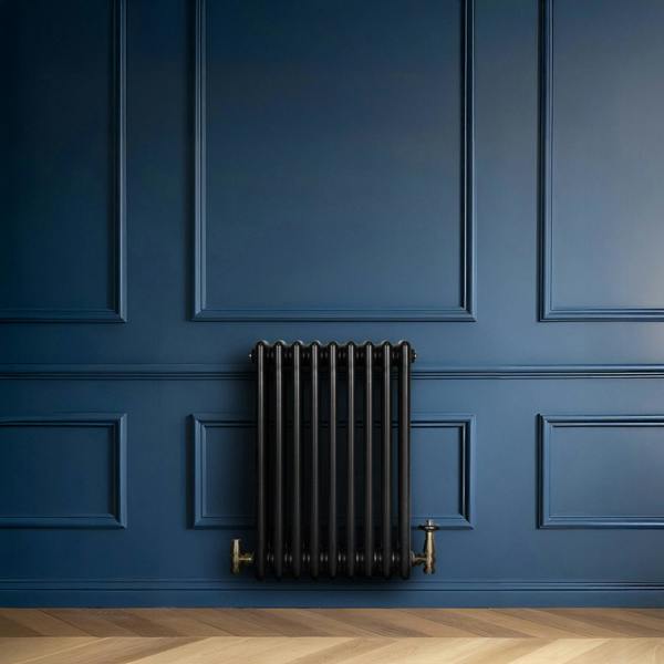 Traditional black 4 column radiator mounted on a deep blue wall, featuring brass valves and a sleek, modern design