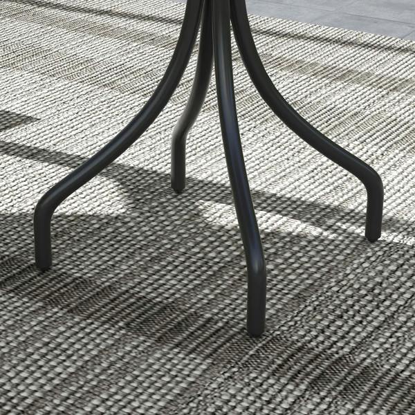Detail of black curved pedestal legs with table supported over outdoor rug.