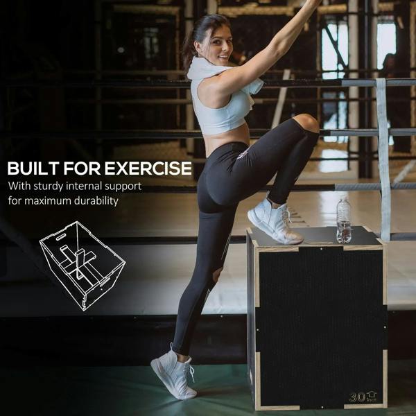 Black wooden multi-height jump box with flat top for step exercise in a gym