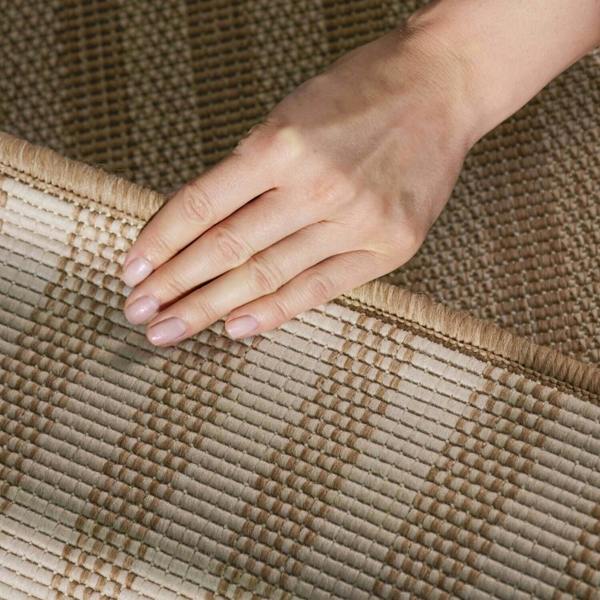 Hand touching a textured woven mat