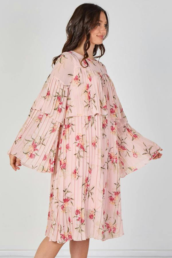 Woman wearing a pink floral dress against a white background