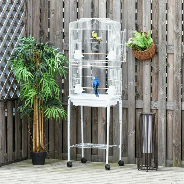 White outdoor bird cage on wheels with wooden perches and three birds