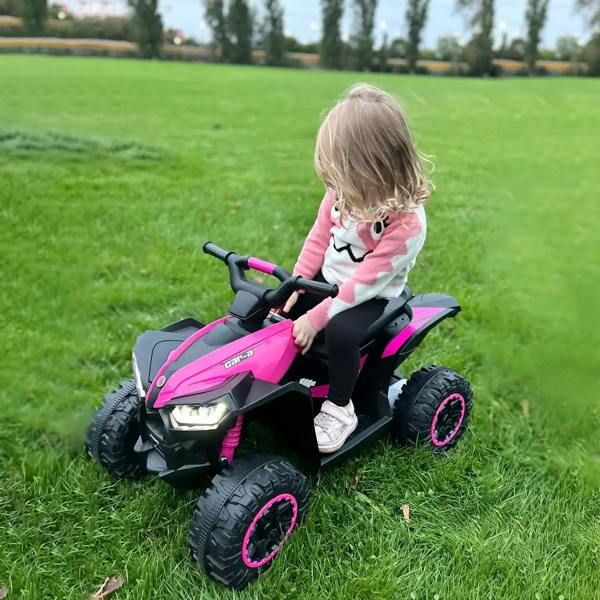 Pink 12V ride-on quad bike with LED lights, child riding on grass