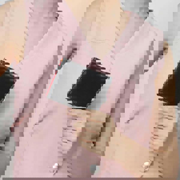 Person holding a black wallet against a plain background