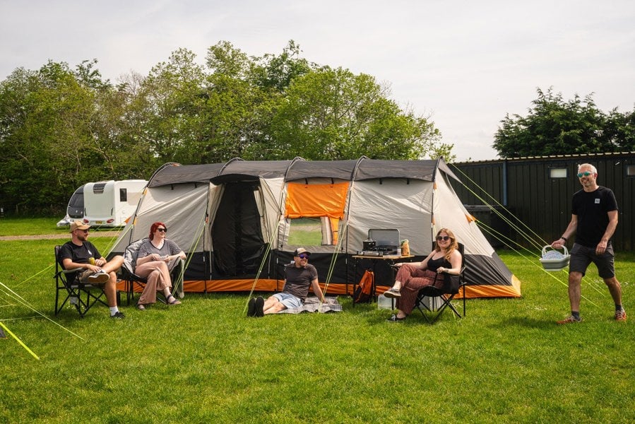 A group of friends gather outside the Wichenford 8.0 poled tent