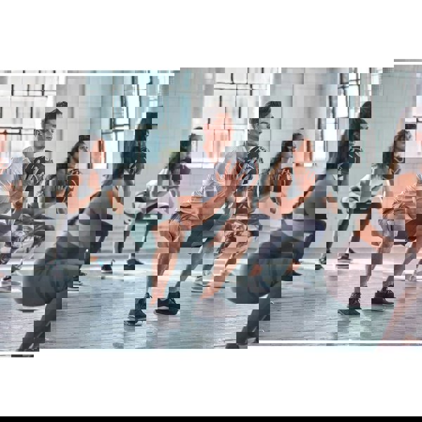 Group of people exercising with medicine balls at a gym class.