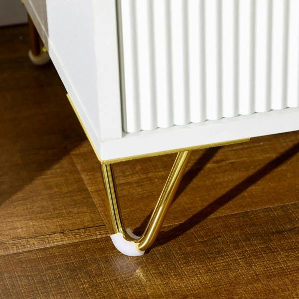 Gold-tone angled legs under a white ribbed two-drawer chest; close-up of corner