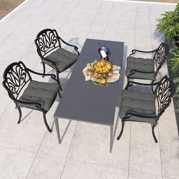 Charcoal gray seat cushions with ties, quilted pads on four outdoor chair seats