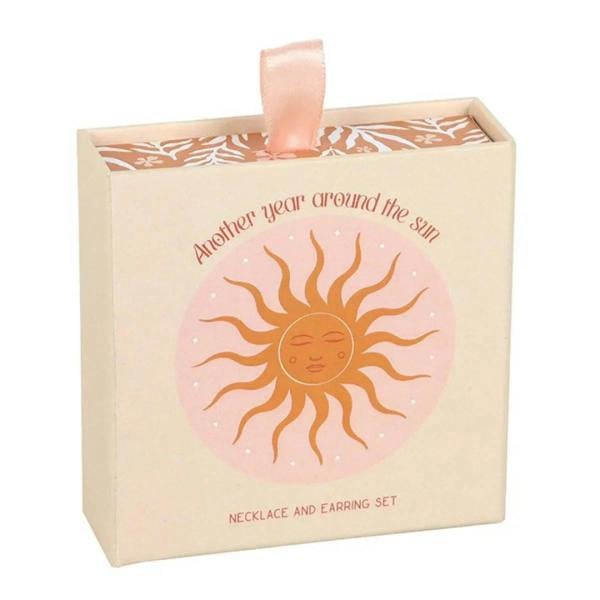 Sun-themed jewelry gift box with ribbon; necklace and earring set design on front