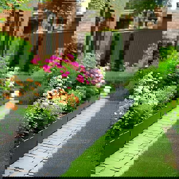 Modern grey metal garden edging bordering a stone walkway, featuring vibrant orange and pink flowers for a contemporary landscaped garden design.