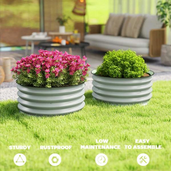 Two green ribbed metal planters holding pink and green flowering plants